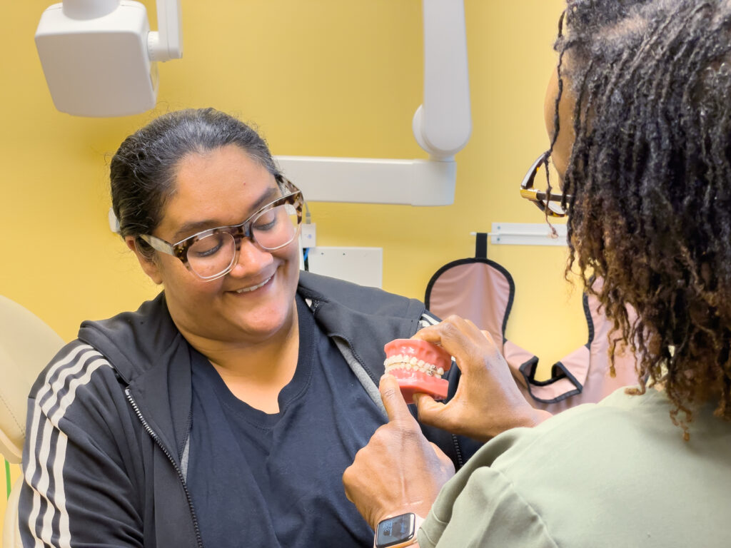 ReNew Dental staff reviewing a dental model with a patient
